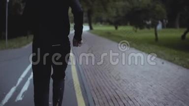 一个人沿着公园路跑。 慢动作。 后景。 <strong>保持</strong>身体健康。 运动员在一个美丽<strong>安静的</strong>公园慢跑。